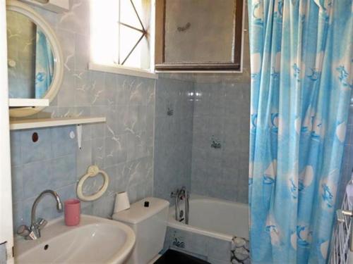 La salle de bains est pourvue d'un lavabo, de toilettes et d'une baignoire. dans l'établissement Village d'Armor, maison à Erdeven, à Erdeven