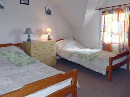 - une chambre avec 2 lits, une commode et une fenêtre dans l'établissement Village d'Armor, maison à Erdeven, à Erdeven