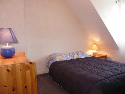 カルナックにあるParc Dran Ty, Carnacのベッドルーム1室(ベッド1台、テーブルの上にランプ付)