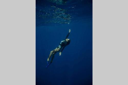 a person swimming in the water in the ocean at Private Oceanfront Fijian Villa Sleeps 8 in Malolo