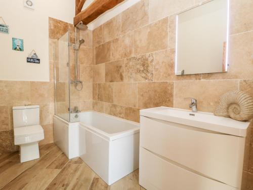 a bathroom with a white sink and a toilet at Snave Cottage in Skipton