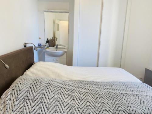 une petite chambre avec un lit et un lavabo dans l'établissement ATLANTIQUE 2 - Belle terrasse, Vue mer - TAT19, à Carnac