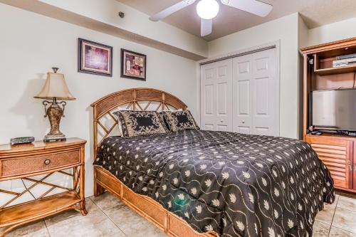 a bedroom with a bed and a flat screen tv at Four Winds in Orange Beach