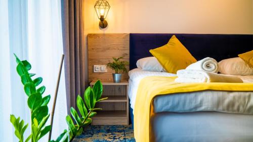 sypialnia z łóżkiem z żółtą i białą pościelą w obiekcie Plaża Resort w Łebie