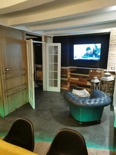 a living room with a couch and a tv at Sweet home San Filippo Industry Style in centro città in Biella