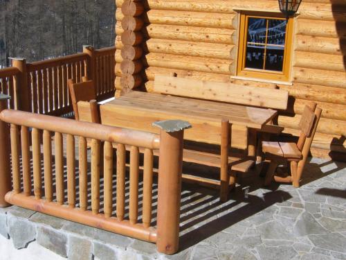 a porch of a log cabin with a table and chairs at Tomperkasa in Apriach