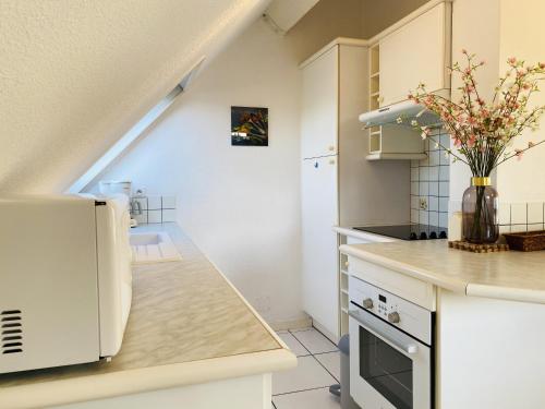 une cuisine avec des armoires blanches et un comptoir dans l'établissement AZUR - Triplex spacieux, Face à la mer, Plage - T1, à Carnac