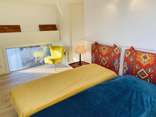 - une chambre avec un lit et une chaise jaune dans l'établissement AZUR - Triplex spacieux, Face à la mer, Plage - T1, à Carnac
