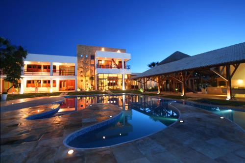 a swimming pool in front of a building at night at Refúgios Parajuru in Parajuru