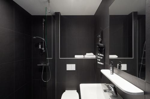 ein Bad mit einer Dusche, einem WC und einem Waschbecken in der Unterkunft The Social Hub Berlin Alexanderplatz in Berlin