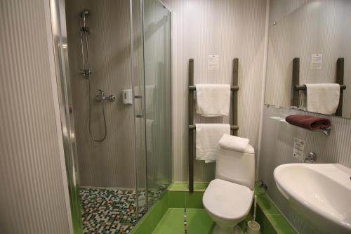 a bathroom with a shower and a toilet and a sink at A1 Hotel Riga City Center in Rīga