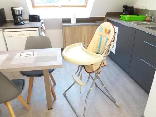 une cuisine avec une chaise haute et une table dans l'établissement APPART HOEDIC, à Surzur