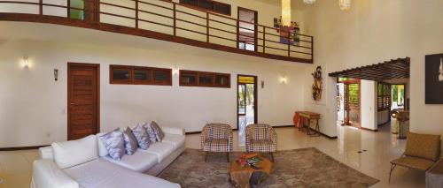 un soggiorno con divano bianco e tavolo di Refúgios Parajuru - Villa Cacau a Parajuru