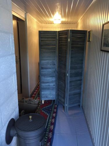 a bathroom with two wooden doors and a toilet at La Chênaie in Vresse-sur-Semois