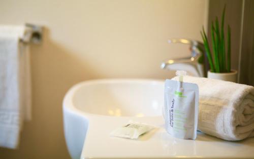 a bathroom sink with a towel and a bottle of toothpaste at Logis Hôtels- Hôtel Marguerite d'Anjou Angers château in Angers