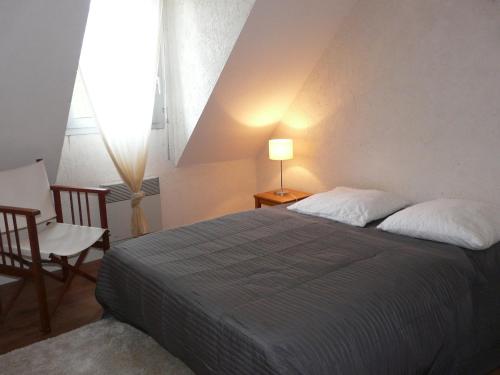 1 dormitorio con cama, lámpara y silla en Ty Kreisker en Carnac