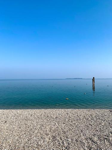 a beach with a pole in the water at Albergo La Pescatrice in Moniga