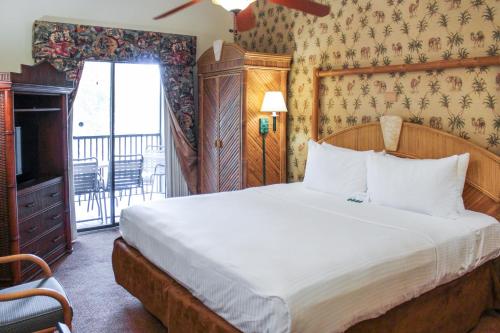Parkway International Resort في أورلاندو: غرفة نوم بسرير كبير وبلكونة