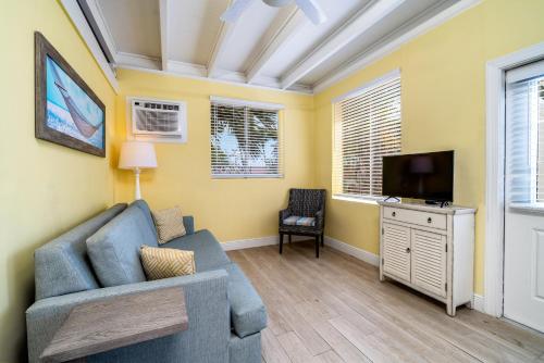 a living room with a blue couch and a tv at Rainbow Bend Resort in Marathon