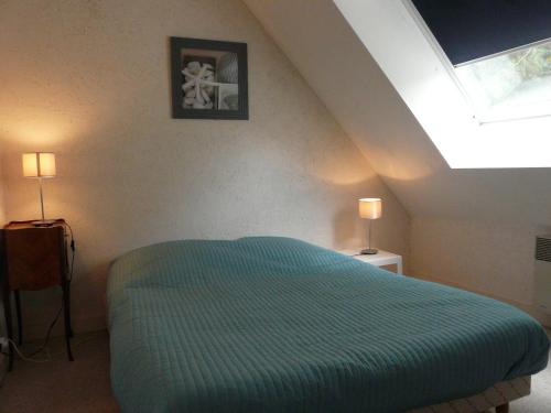 1 dormitorio con 1 cama con edredón azul en Dran Ty en Carnac
