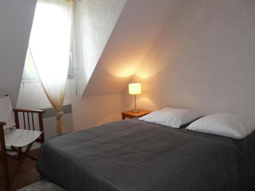 a bedroom with a bed and a lamp and a window at Dran Ty in Carnac