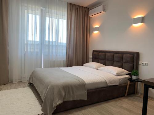 um quarto com uma cama grande e uma janela em Святобор LUX Apartments em Kiev