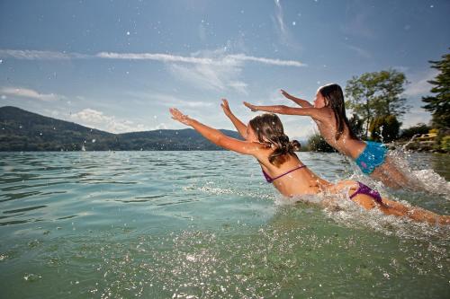 two girls playing in the water on a lake at Pension Linder in Seeboden