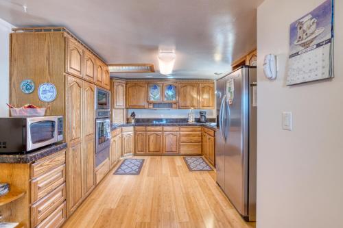 a kitchen with wooden cabinets and a stainless steel refrigerator at Windsong Cove in Netarts
