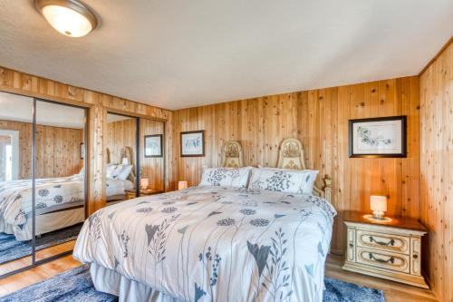 a bedroom with wooden walls and a large bed at Windsong Cove in Netarts