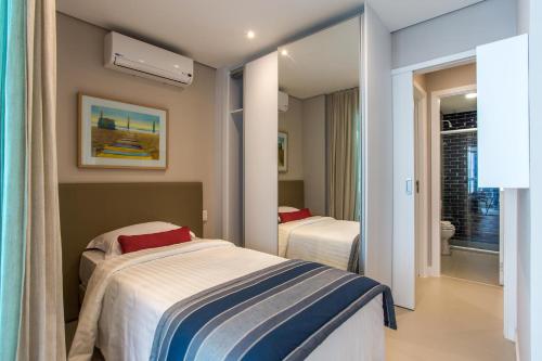 a hotel room with two beds and a bathroom at 2 quartos- Estanconfor Vista Mar AC garagem sacada in Santos