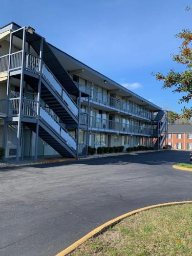 duży budynek apartamentowy ze schodami na parkingu w obiekcie Royal Inn Motel-Charlottesville w mieście Charlottesville