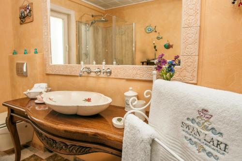 a bathroom with a sink and a mirror at Swan Lake Hotel - Adult Only in Selimiye