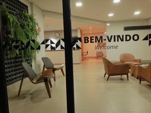 a store with chairs and a sign that reads ben windo welcome at Hotel Horto in Rondonópolis