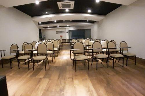 a room with a bunch of chairs in a room at Hotel Horto in Rondonópolis