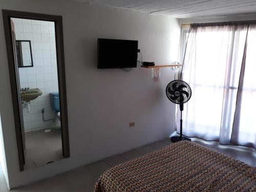 een slaapkamer met een spiegel en een bed en een badkamer bij Posada Loreto Xalapa in Xalapa