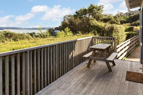 a wooden bench sitting on the deck of a house at Russell Top 10 Holiday Villas in Russell