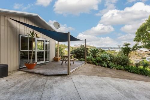 a patio with a blue canopy on a house at Russell Top 10 Holiday Villas in Russell