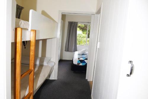 a small room with two bunk beds and a window at Russell Top 10 Holiday Villas in Russell