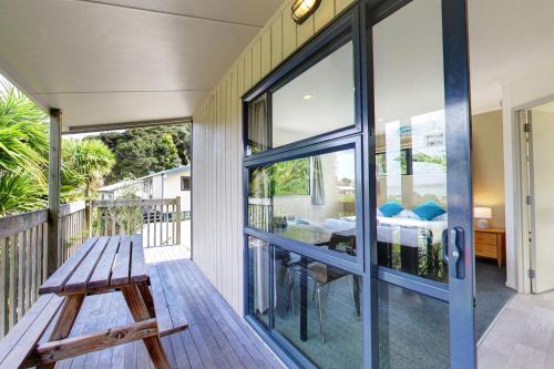 a deck with a bench and a bedroom at Russell Top 10 Holiday Villas in Russell