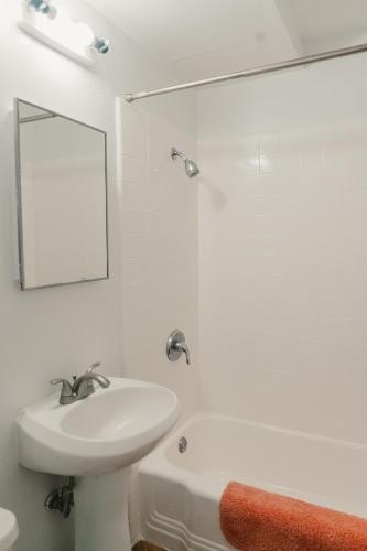 a white bathroom with a sink and a mirror at Polynesian Hostel Beach Club in Honolulu