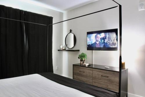 1 dormitorio con 1 cama y vestidor con TV en Modern Building -Free Parking - BY CHOC & St Joseph's Hospital, en Orange