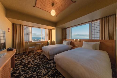 a hotel room with two beds and two windows at JR Kyushu Hotel Blossom Oita in Oita