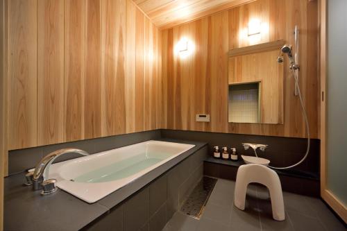 a bathroom with a large tub and a white stool at Nishijin Fujita in Kyoto