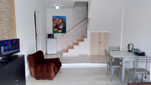 a living room with a staircase and a table and chairs at Simon's place in Ponta Delgada