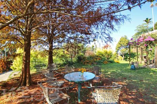 a table and chairs in a park with trees at 朵麗絲森林 in Meishan