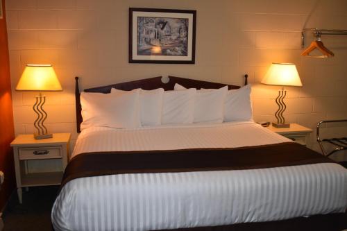 a bedroom with a large bed with two lamps at Hope Inn and Suites in Hope