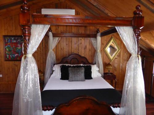 1 dormitorio con cama con dosel y cortinas en Barossa Barn Bed and Breakfast en Angaston