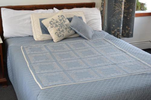 a blue quilt on top of a bed with pillows at Parker's Motel in Lincoln