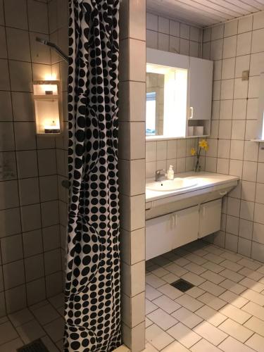 a bathroom with a sink and a shower curtain at Hotel Medio Fredericia in Fredericia