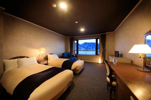 a hotel room with two beds and a window at Yutorelo Nikko in Nikko